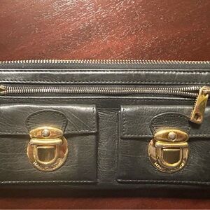 Marc Jacobs black leather wallet with brass decorative tab pockets.